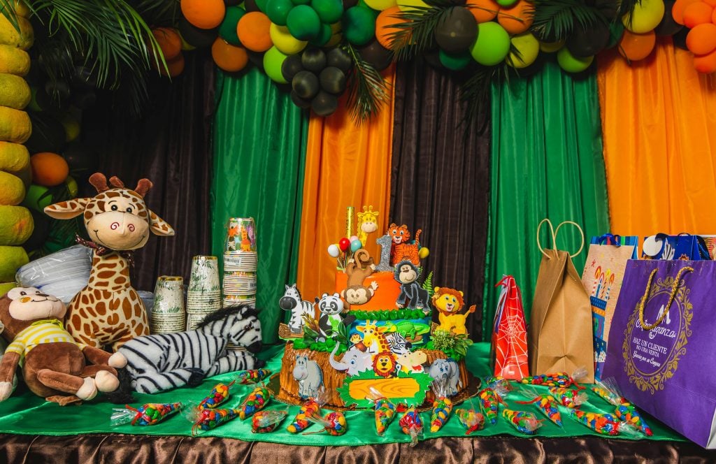 Vibrant safari-themed birthday setup with cake, decorations, and gifts indoors.