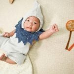 Cute baby lying with creative outfit and colorful props.