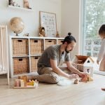 Father engaging with daughter in a playful indoor setting, building memories.