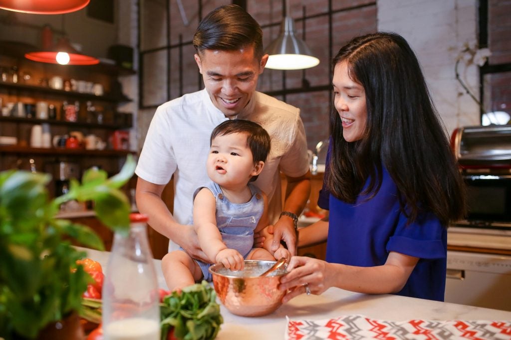 A joyful family bonding in the kitchen while preparing a meal together.